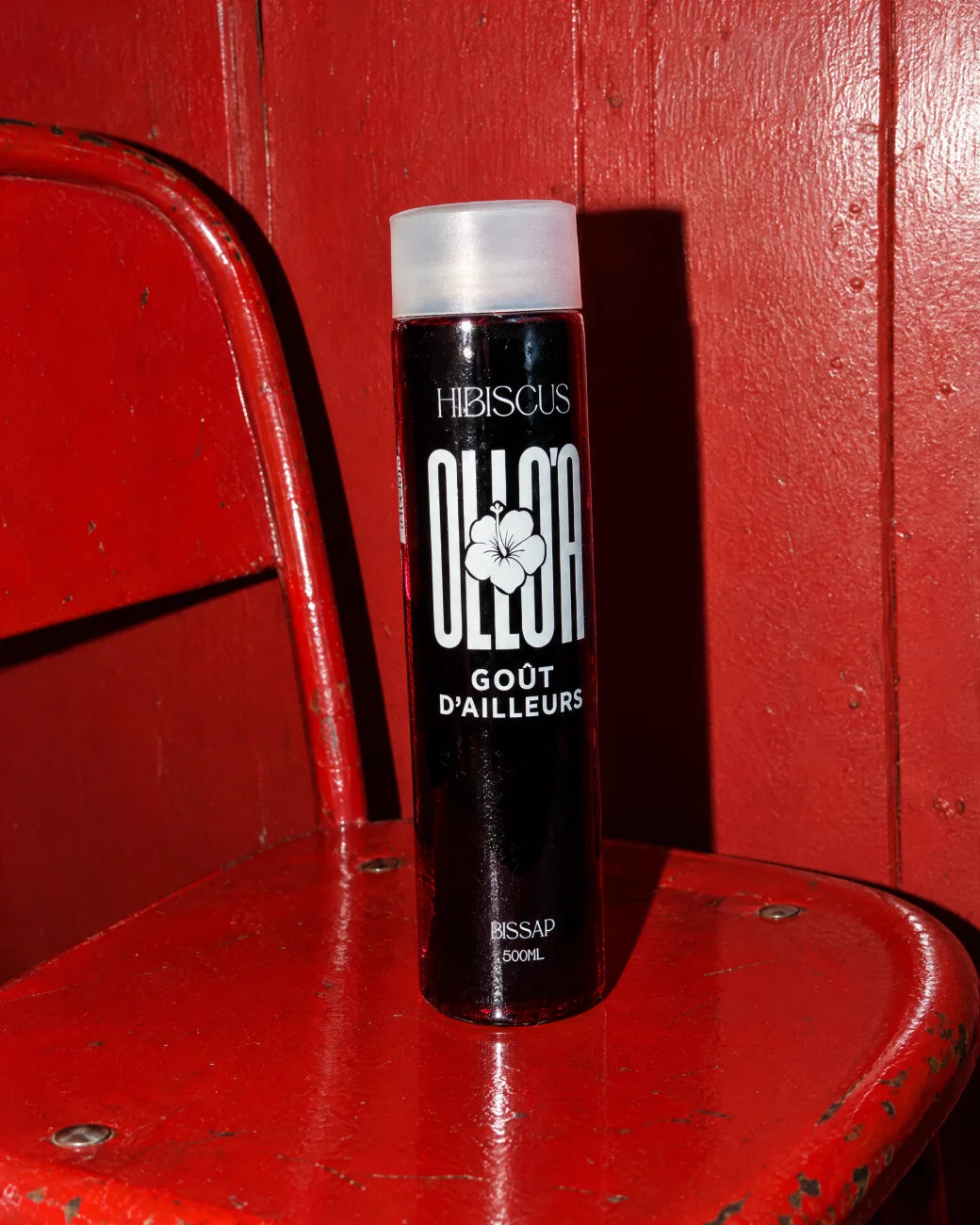 Bouteille de bissap Olloa sur une chaise rouge